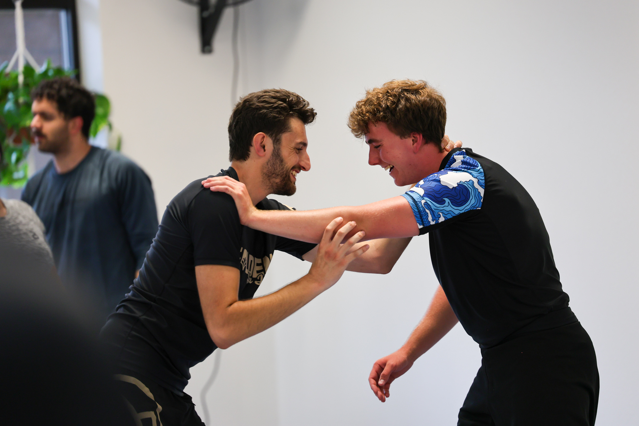 Members laughing during a hand fighting game at Golden Jiu Jitsu