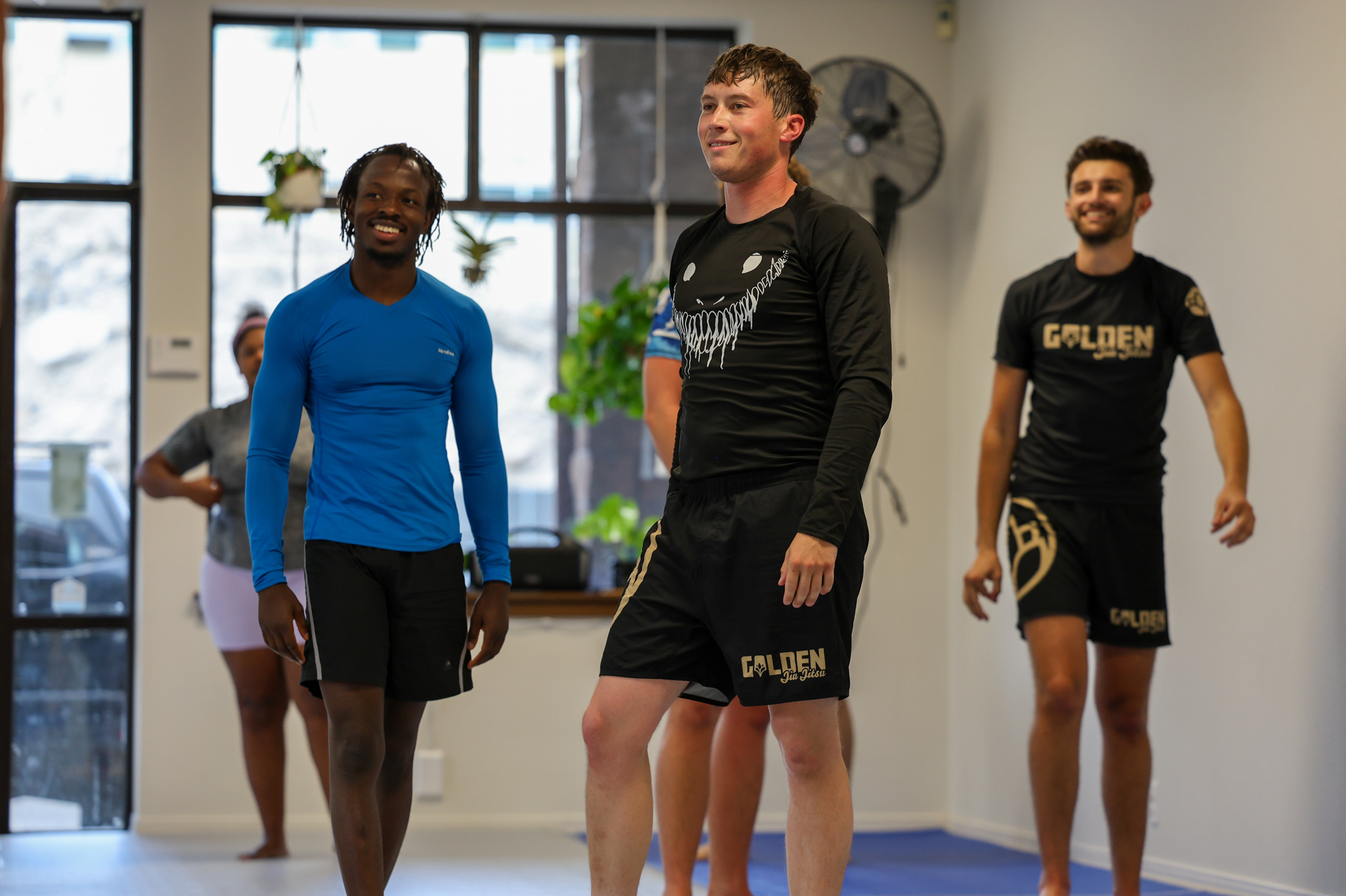 Group of members smiling in no-gi gear at Golden Jiu Jitsu