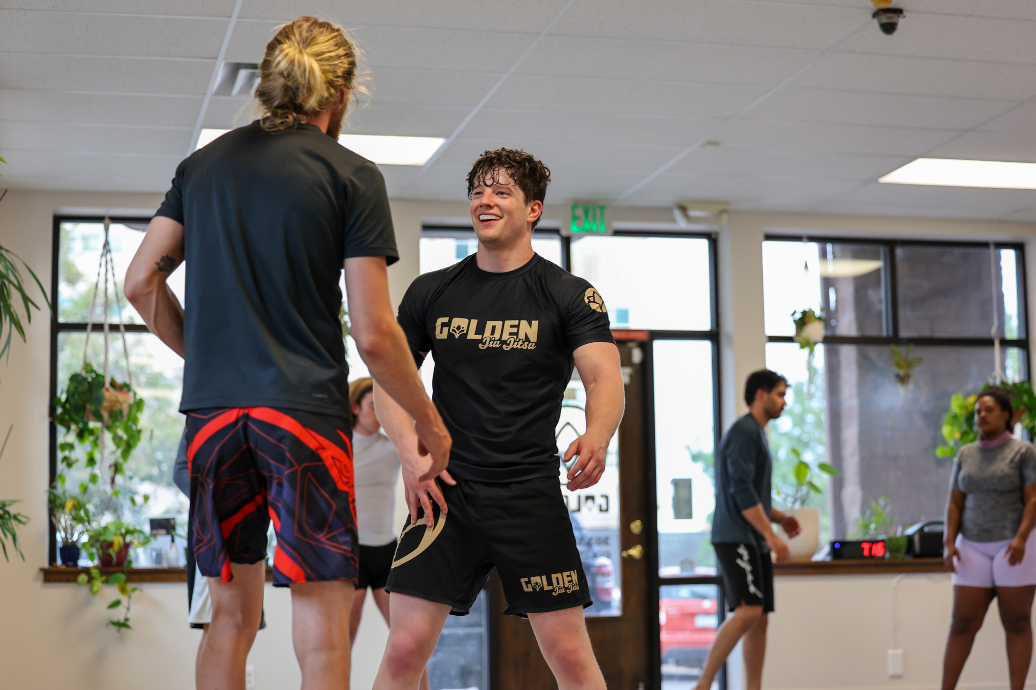 Member grinning at his training partner after a no-gi round at Golden Jiu Jitsu